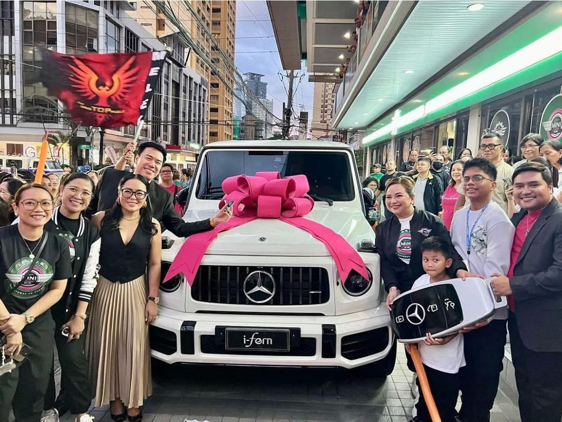 White G-Wagon Mercedes Benz with big pink ribbon on top around the people at i-fern office 